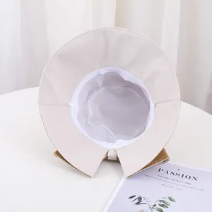 Vue détaillée du bord fendu et du nœud d'un chapeau de soleil beige pour femme.