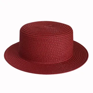 Detailed shot of the red flat top straw hat, showing breathable woven texture and fine craftsmanship.