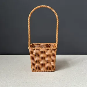 Detailed view of the woven imitation rattan flower basket handle and textured basket body.