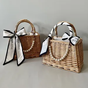 Detail of hand-woven wicker gift baskets featuring elegant pearl handles and silk scarves.