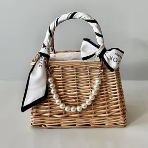 Detailed view of woven rattan gift basket with elegant pearl handle and scarf