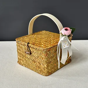 Détail d'un panier cadeau carré tissé avec fleur rose et étiquette de remerciement