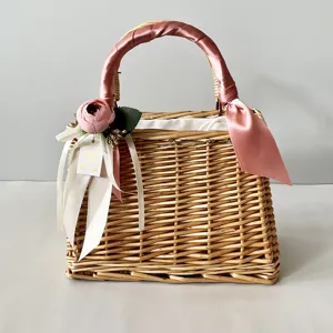 Handmade woven wicker basket with pink ribbons and rose for wedding souvenirs