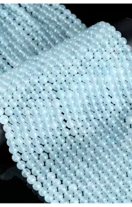 Vista macro de cuentas redondas de calcedonia azul claro para joyería artesanal DIY
