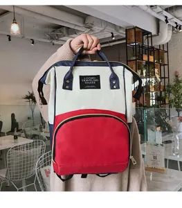 Detail van een driekleurige nylon rugzak met crème rode en blauwe blokken en rits