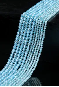 Macro detail of natural blue topaz round beads showing translucency and shine
