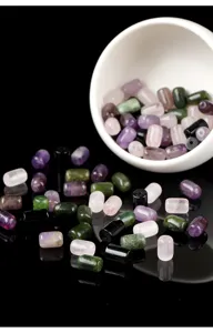 Detailed view of assorted natural gemstone tube beads in pink purple and green for jewelry