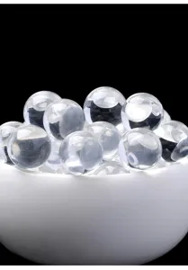 Primer plano de cuentas de cristal de cuarzo natural en un cuenco blanco cerámico