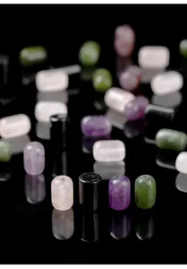 Macro detail view of natural stone cylinder beads in rose quartz and amethyst colors.
