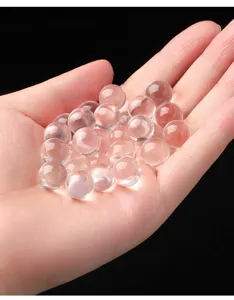 Primer plano de cuentas de cristal de roca en la palma con transparencia de hielo