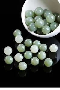 Detailed macro shot of smooth natural light green Hetian jade beads for jewelry making