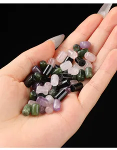 Close-up of mixed natural stone tube beads held in hand for DIY jewelry