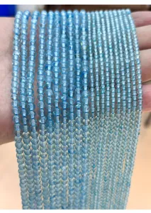 Close-up macro detail of natural blue topaz round beads for DIY jewelry necklace making