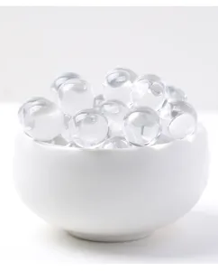 Detalle en primer plano de cuentas de cristal blanco natural en un cuenco blanco.