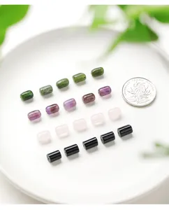 Close-up of cylindrical natural stone beads in various colors for DIY jewelry making.