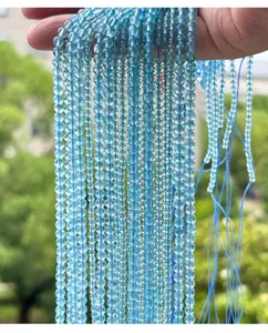 Close-up detail of natural translucent light blue topaz round beads strands for DIY jewelry
