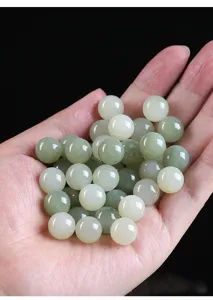 Close-up of natural round polished Hetian jade loose beads for DIY jewelry accessories.