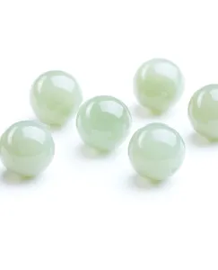 Close-up of translucent pale green natural Hetian jade round beads for jewelry DIY.