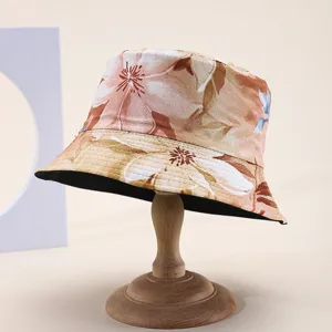 Close-up view of a floral print bucket hat on a wooden stand for vacation sun protection