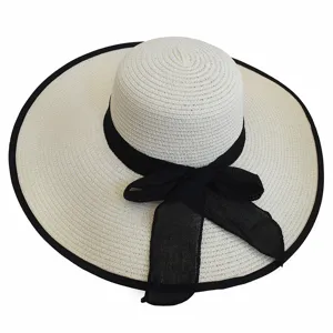 Detailed view of a cream straw sun hat featuring a large brim and a black mesh bow accent