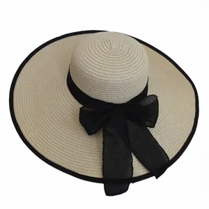 Detailed macro shot of the black ribbon bow and woven texture on this wide brim straw sun hat