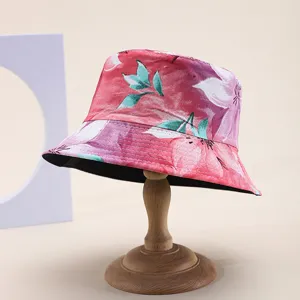 Detailed macro view of a pink floral print bucket hat displayed on a classic wooden stand