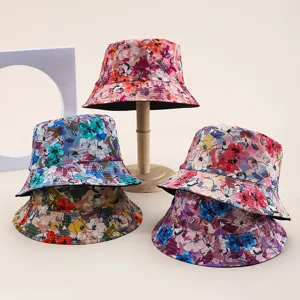Variety of floral print reversible bucket hats for women on a stylish wooden stand display