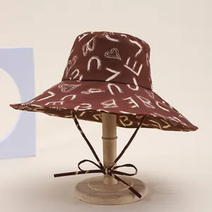 Brown wide brim bucket hat for women with stylish white letter and heart print for summer beach.