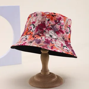 Detailed view of a reversible floral bucket hat for sun protection on a wooden stand.