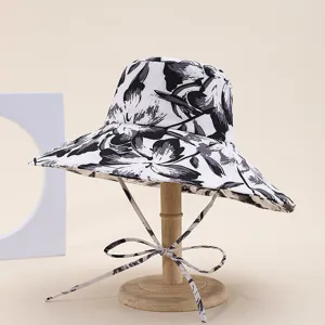 Close-up detail of the black and white floral wide brim bucket hat with stylish ties.