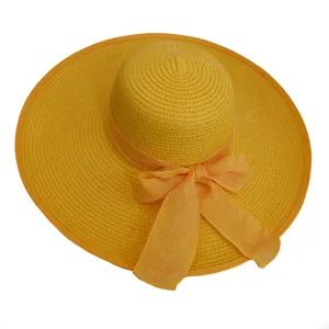 Detailed top-down view of a wide-brim yellow straw sun hat featuring a decorative bow