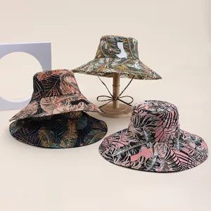 Detail shot of women's wide brim bucket hat with digital tropical leaf print for beach sun.