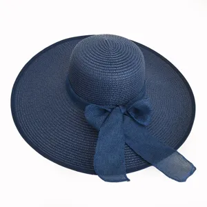Detailed view of navy blue wide-brim straw sun hat with elegant ribbon bow for women