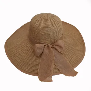 Detailed view of khaki wide brim straw sun hat with bow tie decoration for beach travel
