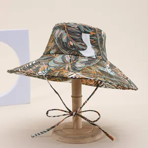 Details of the wide-brim tropical leaf bucket hat featuring digital print and chin ties.