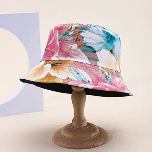 Reversible floral print bucket hat for women displayed on a vintage wooden stand