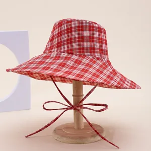 Red plaid bucket hat for women, wide brim foldable sun protection beach hat detail.