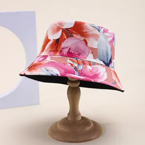 Detailed view of a reversible floral print sun bucket hat displayed on a wooden stand