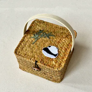 Handcrafted woven gift basket with handle and embroidered bamboo panda design, stylish storage.