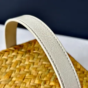 Handmade woven gift basket detail shot featuring natural rattan texture and white leather handle.