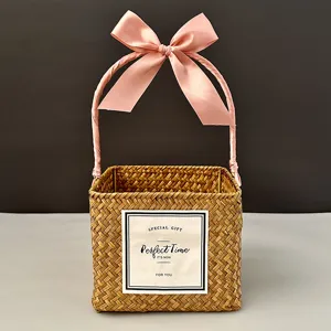 Square hand-woven straw gift basket with elegant pink ribbon and decorative card