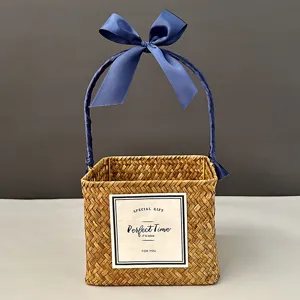 Handmade square straw woven gift basket with elegant blue ribbon handle and bow detail
