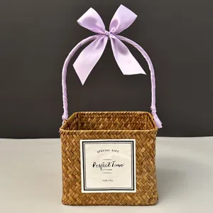 Handwoven square gift basket with purple ribbon handle and decorative bow
