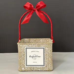 Handmade square woven gift basket featuring a red ribbon handle and a gift label