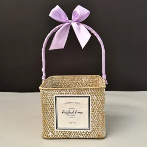 Detailed view of square woven gift basket with purple ribbon bow handle