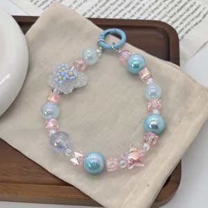 Detailed view of a handmade colorful beaded butterfly phone charm with blue pearls and star bead
