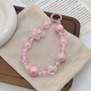 Close-up of pink iridescent beaded phone strap with floral butterfly charm