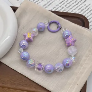 Close-up of purple iridescent beaded phone charm with star and letter E decoration
