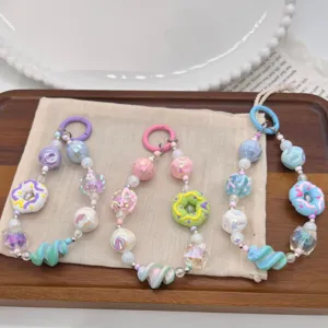 Detailed view of colorful dopamine style beaded phone charms with cute donut charms