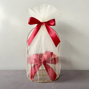 Golden metal gift basket with white tulle and red ribbon bow for wedding and party favors